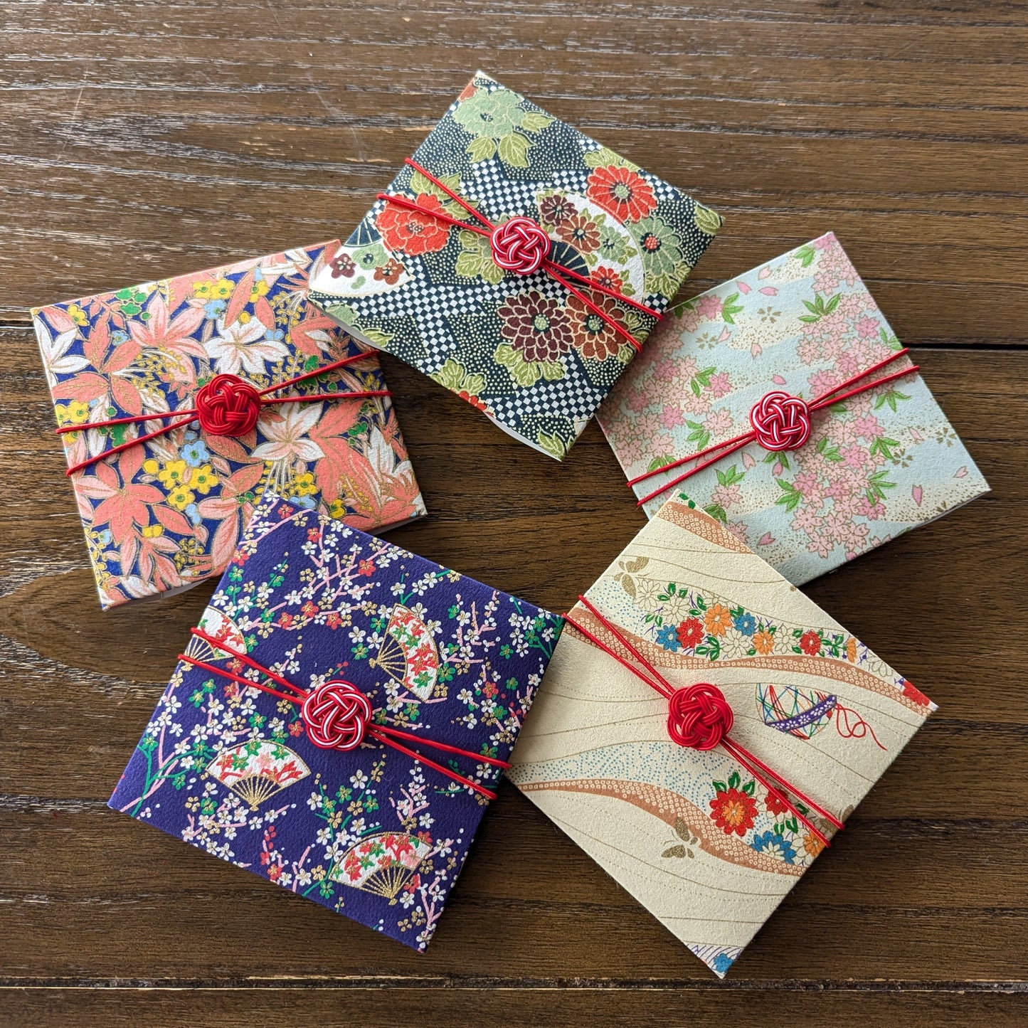Colorful Japanese Washi paper envelopes with floral patterns and red ribbons on the package.